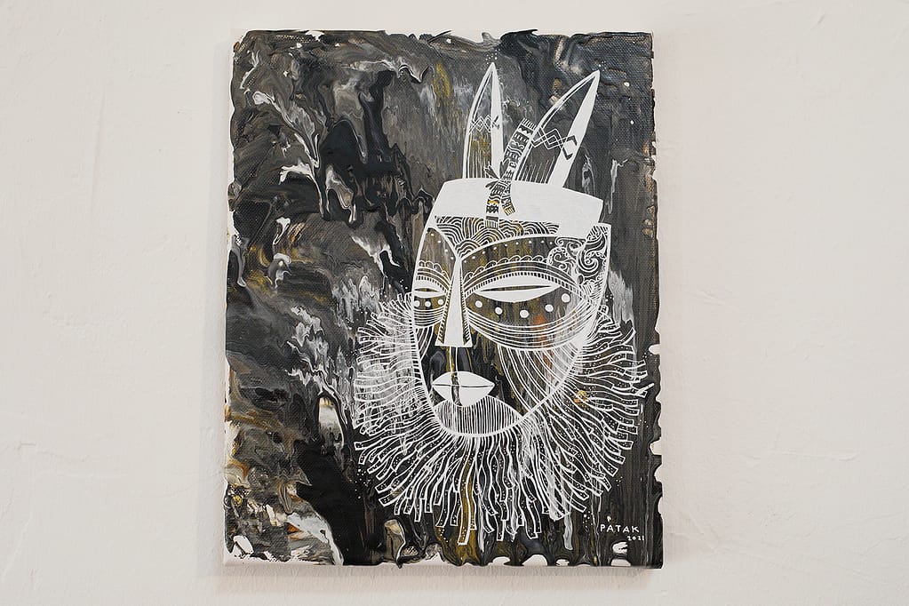 Painting of a mask on a dark background.