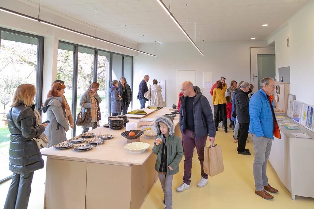 People standing around a table, discovering the work for the exhibition.